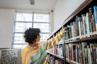 femme choisie genre de lecture dans bibliothèque